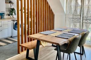kuchnia z drewnianym stołem i krzesłami w pokoju w obiekcie Comfy flat 7 min away from Disney w mieście Serris