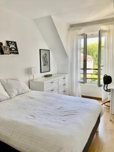 a white bedroom with a bed and a window at Comfy flat 7 min away from Disney in Serris