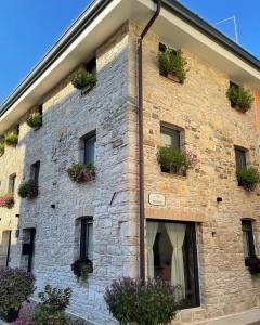 a brick building with potted plants on it at Onda Marina B&B Superior in Marano Lagunare