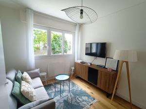 salon z kanapą i telewizorem z płaskim ekranem w obiekcie Studio 5 min du centre-ville w La Rochelle