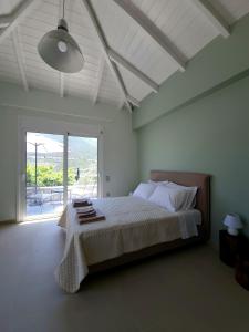 a bedroom with a large bed and a large window at Melissafarm Guest House in Ancient Epidauros