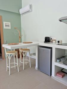 una cucina con bancone, sgabelli e frigorifero di Melissafarm Guest House ad Antica Epidauro
