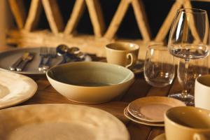 a wooden table with plates and glasses and a bowl at Private Studio Apartment, Unique Location - Sea View in Lithakia