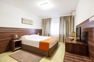 a hotel room with a bed and a television at Hotel Citadella in Bucharest +28 photos