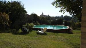 a swimming pool in a field with chairs in a yard at La Panoramica in Avenale