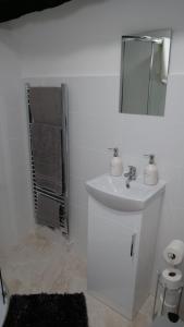 uma casa de banho branca com um lavatório e um espelho em MK Shortstay Deluxe em Milton Keynes