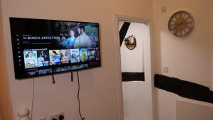 TV de pantalla plana colgada en la pared en MK Shortstay Deluxe en Milton Keynes