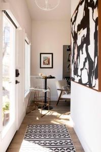 a hallway with a door and a table and a rug at The Studio on Ast., Downtown Bentonville near all! in Bentonville