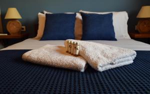 a pile of towels on a bed in a bedroom at Blu Casa Del Mare in Monemvasia