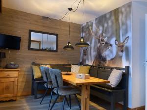 a dining room with a table and a painting of deer at Ruim en modern appartement super centraal gelegen aan de piste in Valmorel