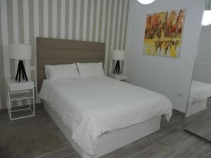 a bedroom with a white bed and two tables and two lamps at SUNHILL LUXURIOUS house in Arguineguín