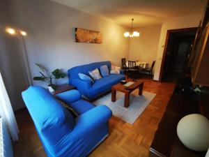 a living room with a blue couch and a table at Apartamento Centro Gijón in Gijón