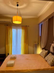 a bedroom with a large bed with a yellow window at Central flat - 2 Metro stops from ACROPOLIS-PLKA in Athens