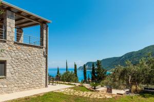 a stone house with a view of the ocean at Mylos Mountain Villas- Villa Giorgio in Agios Nikitas