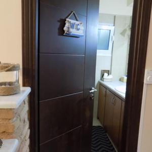 a bathroom with a large wooden door with a sink at Nikos House Megara in Megara +31 photos