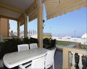 a table and chairs on a porch with a view of the ocean at Villa Liberty in San Vincenzo