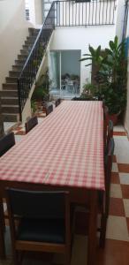 a red and white checkered table with chairs and stairs at Residencial Bibi in Ribeira Grande