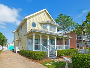 a yellow house with a white porch and bushes at Walking on Sunshine by Newman-Dailey in Destin