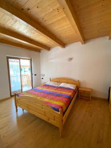 - une chambre avec un lit dans une pièce dotée de plafonds en bois dans l'établissement Casa Fiemme Panchià, à Panchià