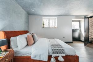 1 dormitorio con 1 cama con sábanas y almohadas blancas en Bunkers Barn, 2 bedroom luxury stay with parking en Leverstock Green