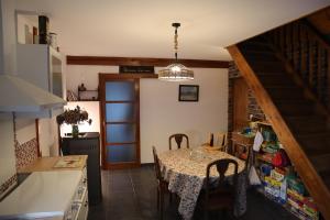una cucina e una sala da pranzo con tavolo e sedie di Kleene Geluk - Chambres et table d'hôtes a Saint-Jans-Cappel