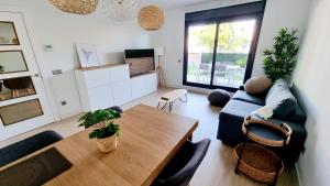 ein Wohnzimmer mit einem Tisch und einem Sofa in der Unterkunft Apartamento diseño con jardín privado a 100 metros del mar in Torredembarra