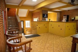a large room with chairs and a kitchen and stairs at RP HOTEL in Ribeirão Preto
