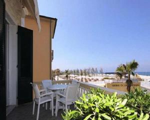 a balcony with a table and chairs and the beach at Villa Liberty in San Vincenzo