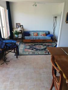 een woonkamer met een bank en een tapijt bij Dazzling 2-bedrooms with terrace near the beach - Dodo et Tartine in Le Pradet