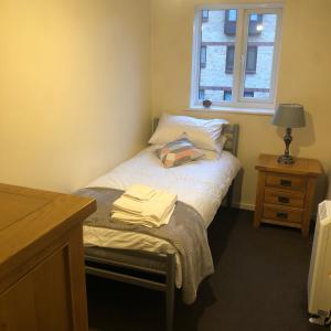 een kleine slaapkamer met een bed en een raam bij 2 Bedroom, Near Station, Fast WI-FI, Free Parking! in Londen