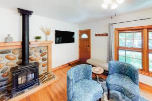 a living room with a fireplace and two chairs at Grand Avenue Retreat in Bozeman