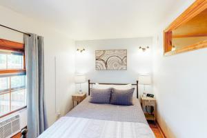 een slaapkamer met een bed met 2 lampen en een raam bij Grand Avenue Retreat in Bozeman