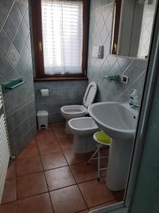 a bathroom with two toilets and a sink and a mirror at La casa di Walter e Rosa in Castel di Sangro