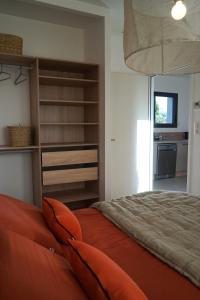 een slaapkamer met een oranje bed en een keuken bij Maison neuve chaleureuse en Provence, terrasse in Piolenc