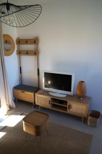 een woonkamer met een televisie op een houten entertainmentcentrum bij Maison neuve chaleureuse en Provence, terrasse in Piolenc