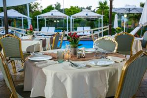 a table with white table cloths and chairs at a restaurant at Fitosinn Hotel in Paphos