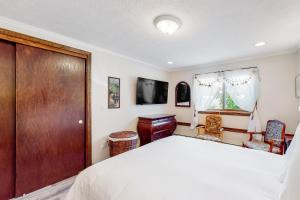 um quarto com uma cama, uma porta de madeira e uma televisão em Seaside Haven em Old Orchard Beach
