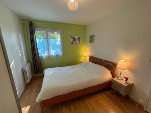a small bedroom with a bed and a window at Les Pléiades in Noisy-le-Grand