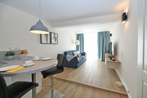 Una cocina y una sala de estar con mesa y sillas. en Das schiefe Haus Wohnung St Peter, en Heppenheim an der Bergstrasse 5 fotos más