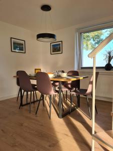 d'une salle à manger avec une table, des chaises et une fenêtre. dans l'établissement Siedlisko pod Topolą, à Giżycko