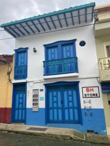 ein blau-weißes Gebäude mit blauen Türen und einem Balkon in der Unterkunft JericóHouse apto 202 in Jericó
