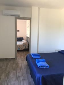 奧爾比亞的住宿－La Maison di Zia Annina in Sardegna，一间设有两张蓝色床单的床的房间