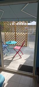 eine Terrasse mit 2 Stühlen, einem Tisch und einem Zaun in der Unterkunft Bedroom Agde 34300 in Agde