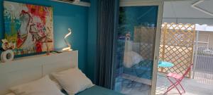 アグドにあるBedroom Agde 34300のベッド1台付きの部屋、パティオに面したガラスドアが備わる客室です。
