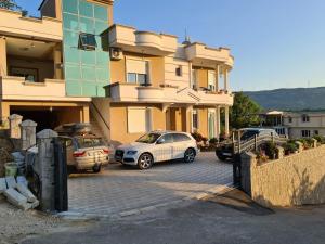 two cars parked in a parking lot in front of a building at Lida apartments in Ulcinj
