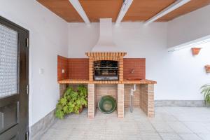 a outdoor kitchen with a pizza oven in a room at Murta's Home in Cadaval