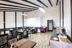 a dining room with tables and chairs and windows at Hotel Citadella in Bucharest