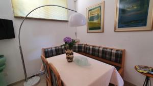 a table with a vase of purple flowers on it at Apartments Ginkgo in Banjole
