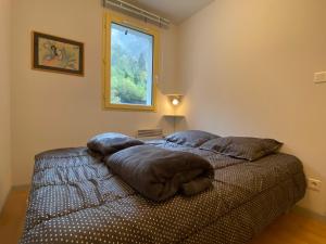 sypialnia z łóżkiem z poduszkami i oknem w obiekcie T2 alcove confortable pour 4 à 5p. Balcon. Parking w mieście Cauterets