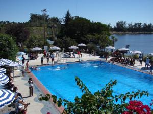 a large blue swimming pool with people standing around it at Las Barrancas Apart & Spa in Necochea